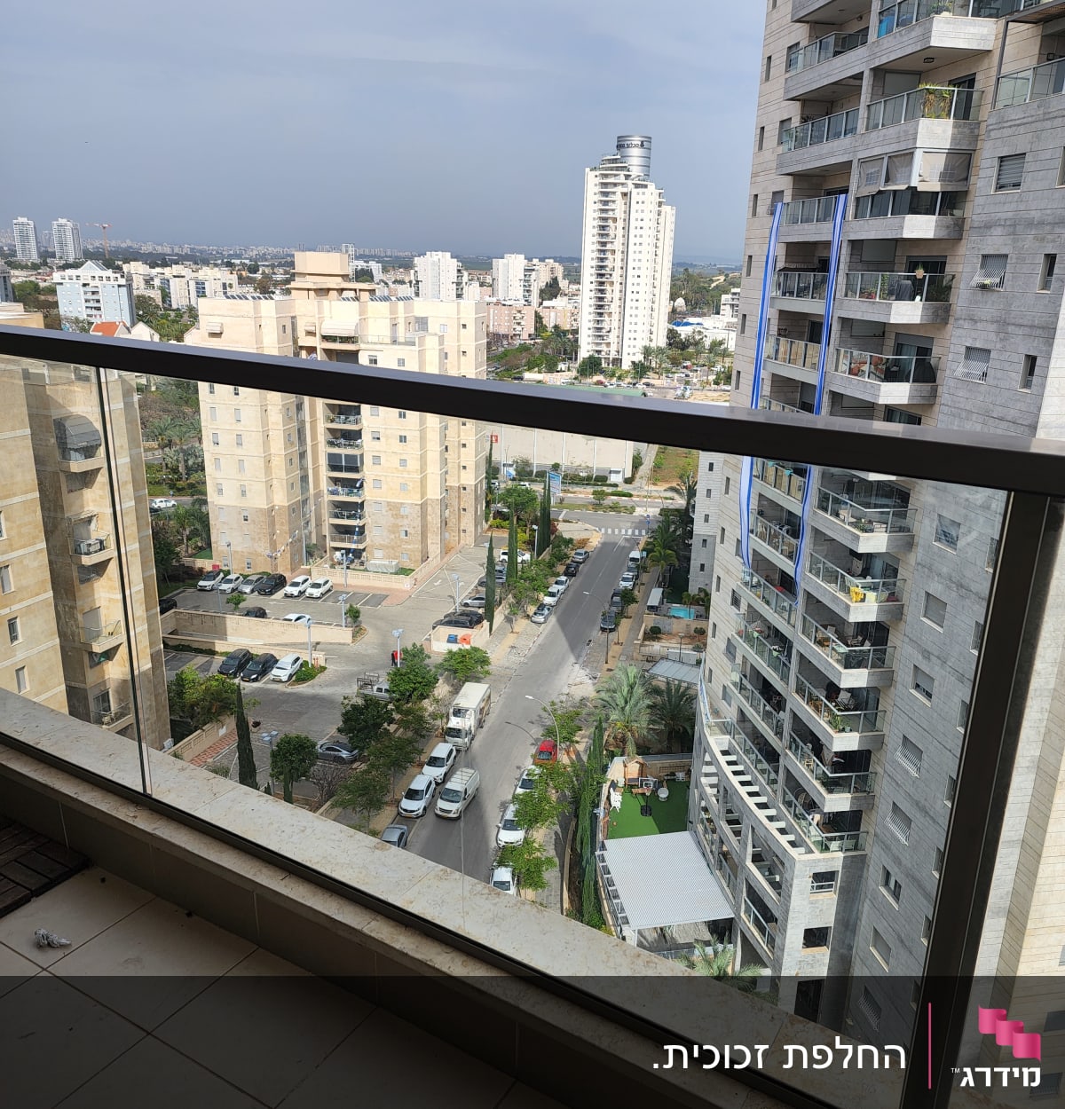 מעקה זכוכית במרפסת עם נוף עירוני